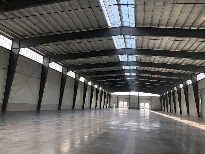 Nave de acero de gran claro sin columnas que muestra cuándo conviene el acero frente a la madera